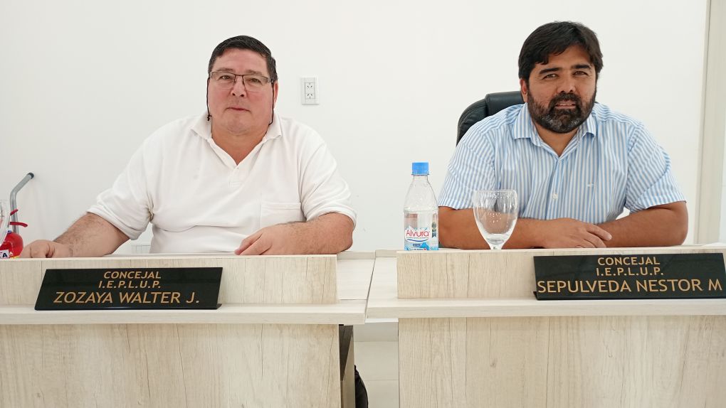 Los concejales Walter Zozaya y Martín Sepúlveda conversando con vecinos frente a un edificio público descuidado en Rincón de los Sauces.  Pie de Imagen