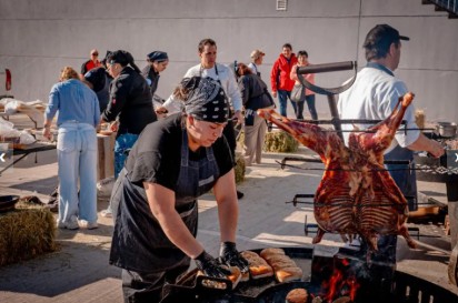 Chefs cocinando en un evento al aire libre en un entorno natural.