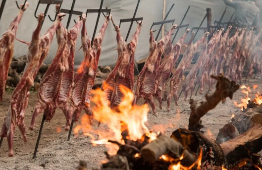 Imagen de la Fiesta del Chivo en Chos Malal con crianceros o chivos asándose.