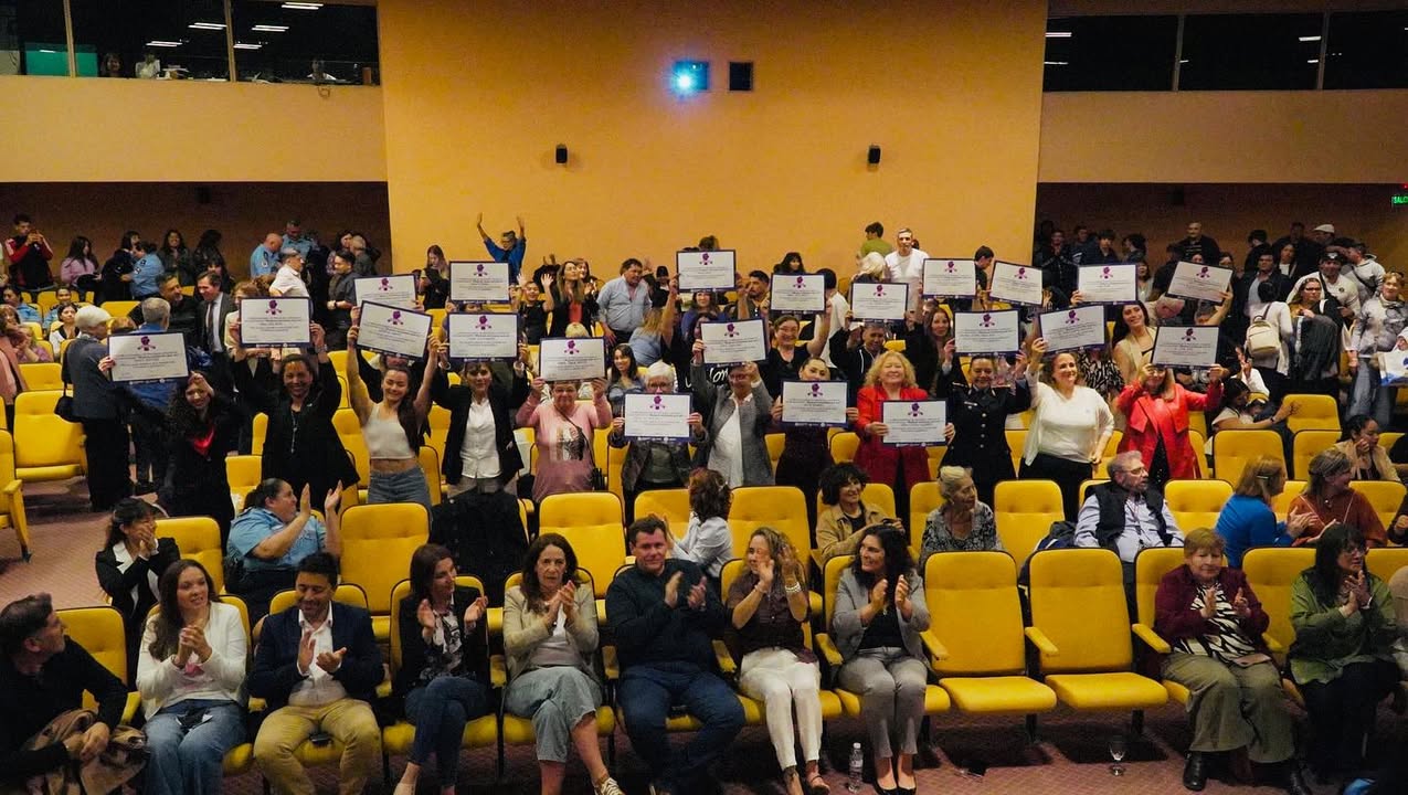 Grupo de mujeres destacadas recibiendo un reconocimiento en un escenario.