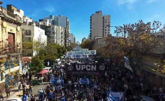 Manifestantes en una marcha, mostrando carteles y banderas.