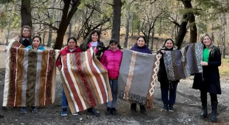 Mujeres de la comunidad mapuche Linares recibiendo un crédito de parte de autoridades provinciales.