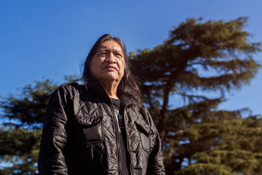 Rubén Patagonia en el escenario con su tradicional vestimenta y su mirada profunda, representando el folclore del sur.